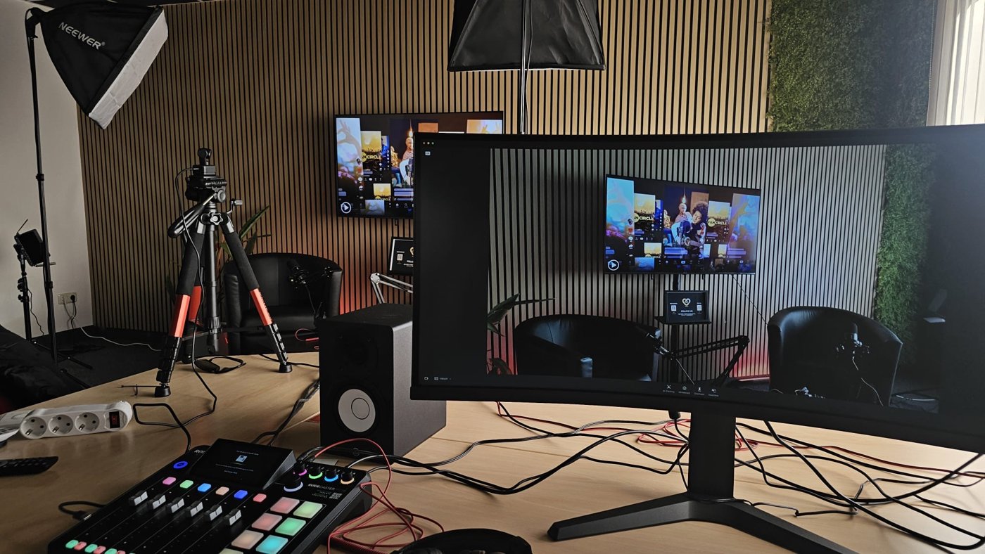Produktionsplatz mit Monitoren und Blick auf das Gesprächs-Setup im Contentraum